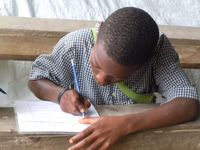 Haiti Eleve penche sur sa feuille
